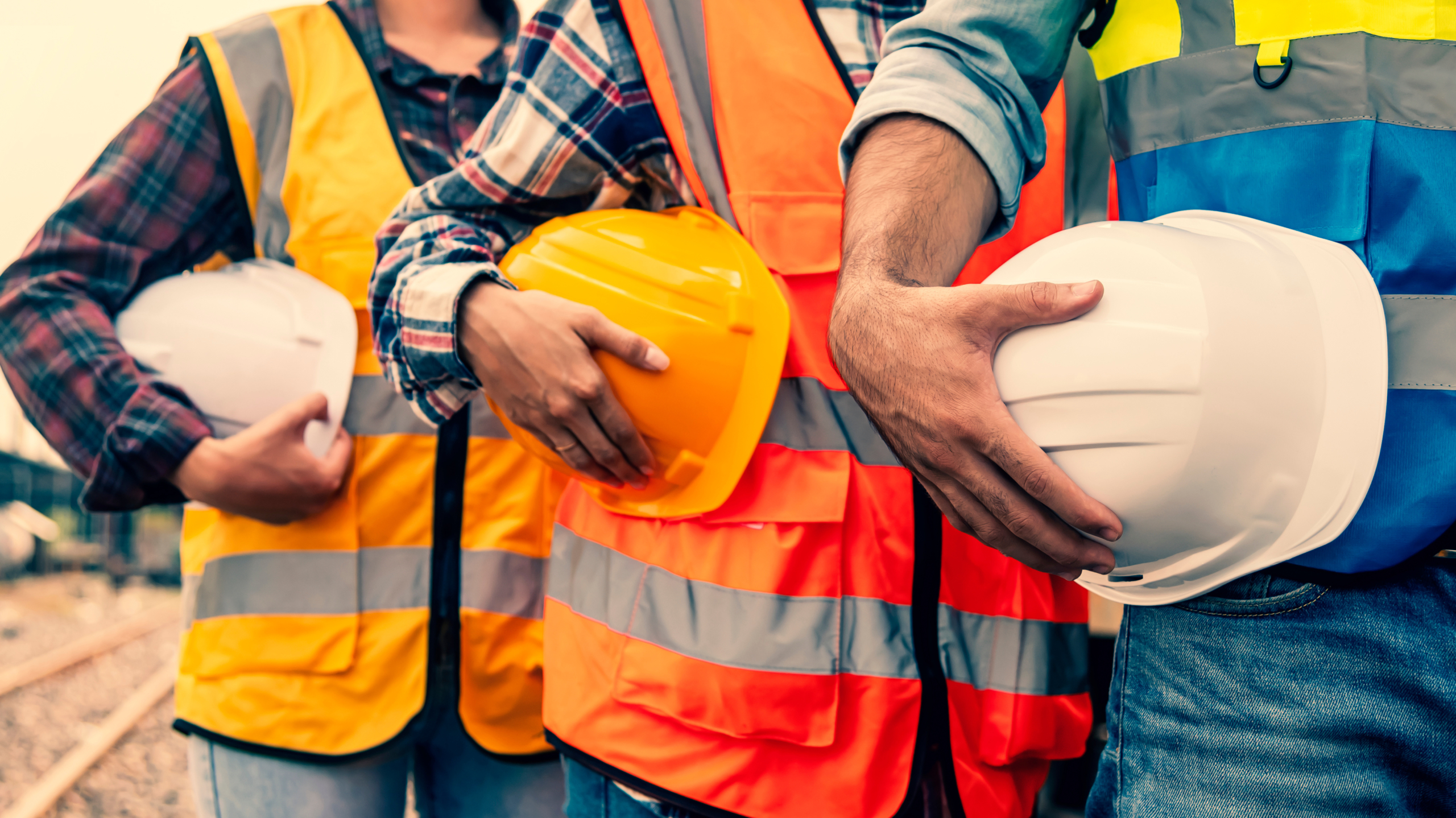 team engineer holding helmet standing in row on site work at tra